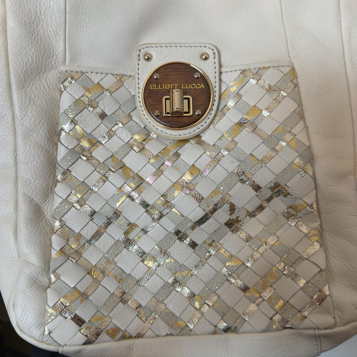 Tag view of cream leather crossbody bag worn on shoulder, showing quilted panel and overall silhouette
