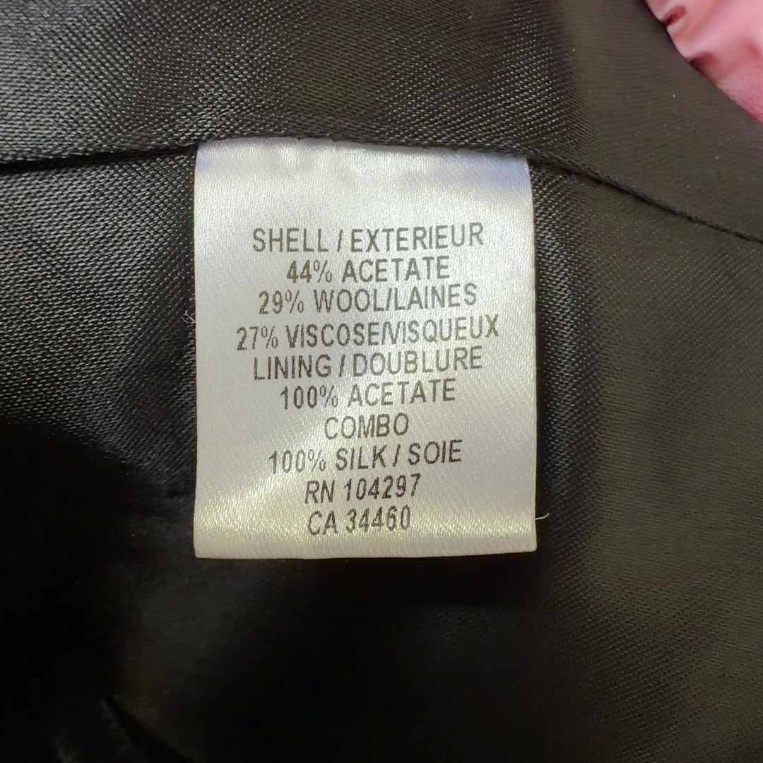 Tag view of black geometric cropped jacket showing three-quarter sleeves and structured silhouette