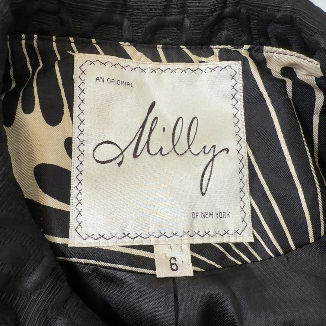 Tag view of black geometric cropped jacket showing three-quarter sleeves and structured silhouette
