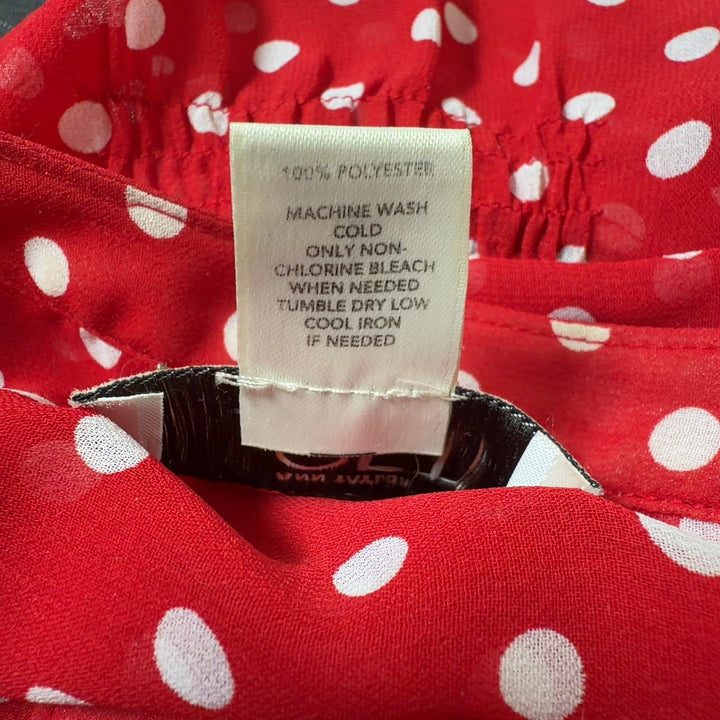 Tag view of red polka dot blouse showing relaxed fit and short sleeve design