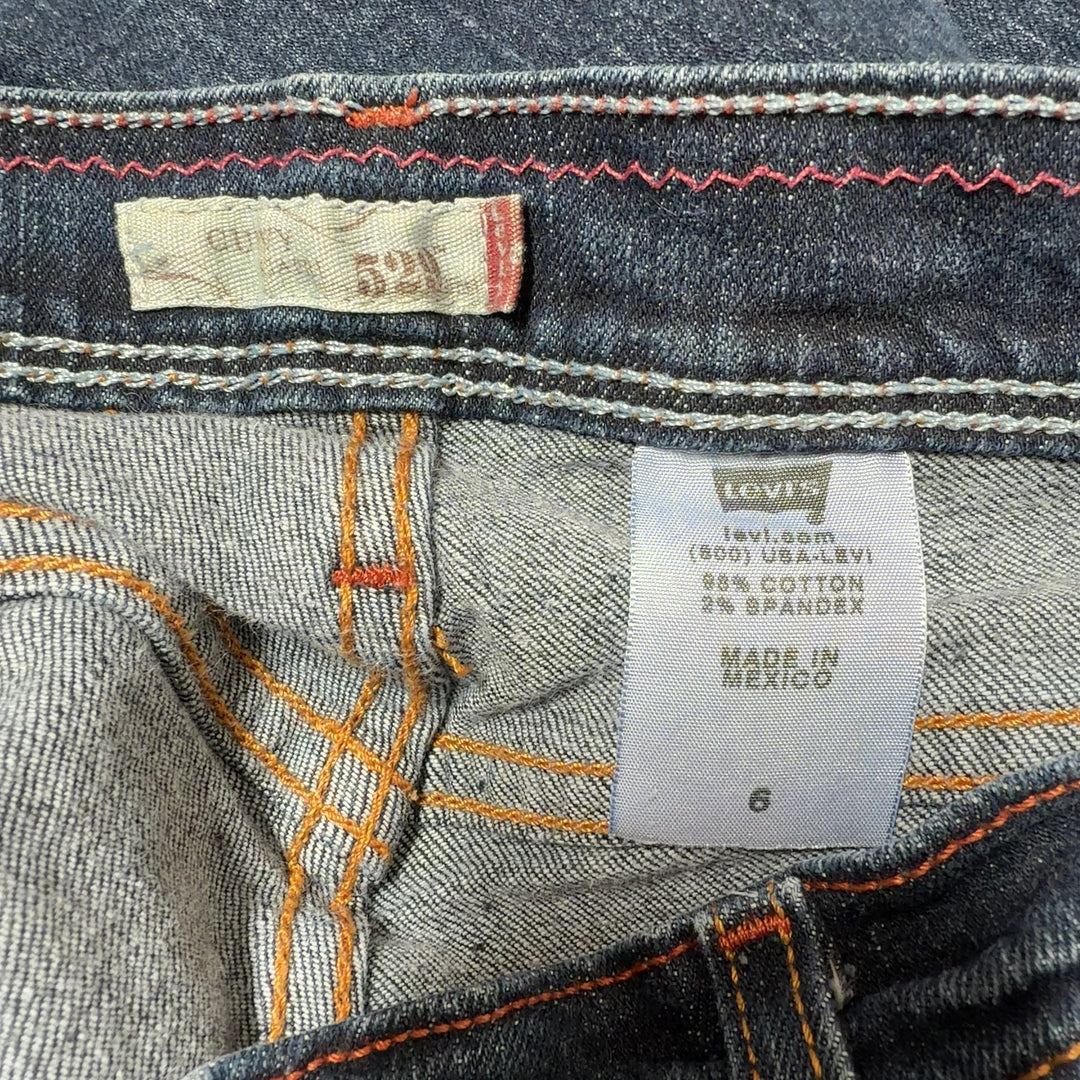 Tag view of dark blue Levi's cropped denim jeans showing classic five-pocket design and fitted silhouette