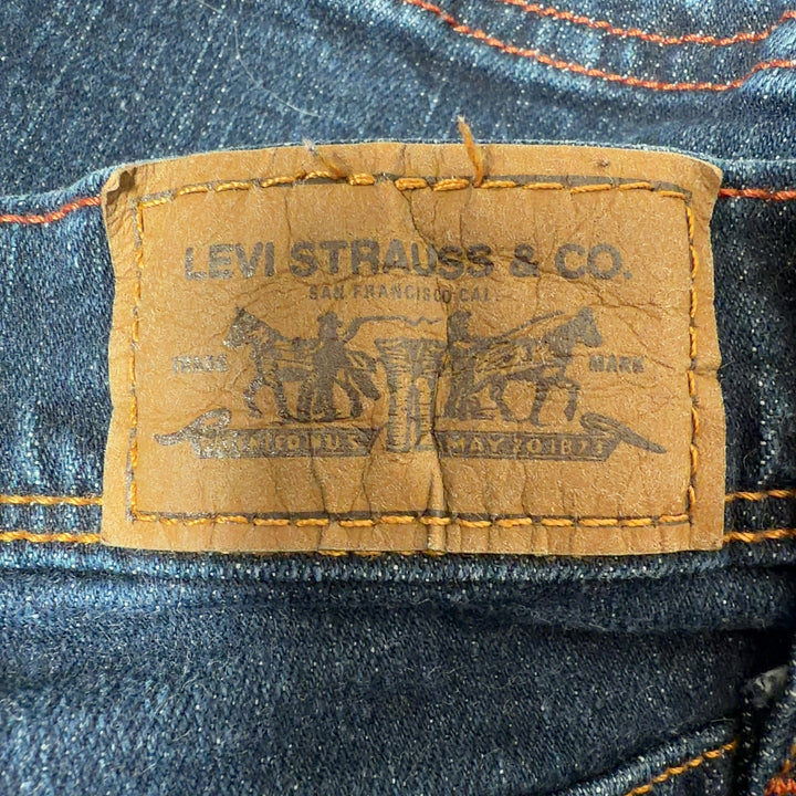 Tag view of dark blue Levi's cropped denim jeans showing classic five-pocket design and fitted silhouette