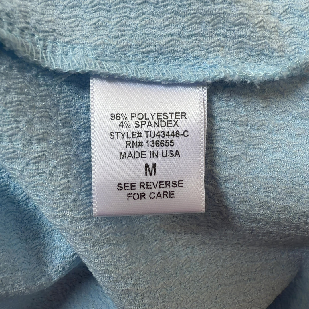 Tag view of light blue collared pullover top showing relaxed fit and gathered sleeve cuffs
