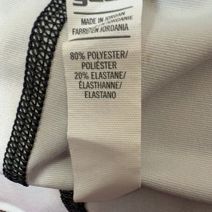 Tag view of pink geometric print Under Armour athletic shorts showing jacquard pattern and fit
