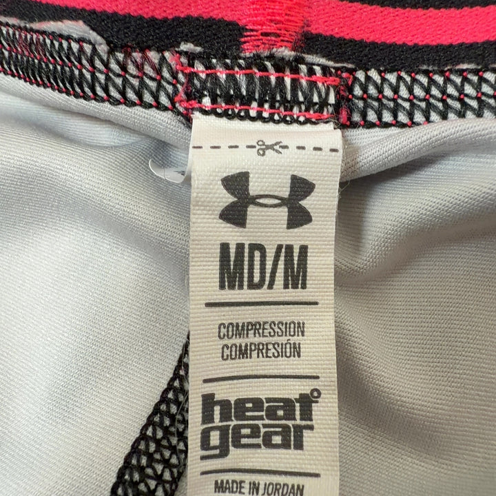 Tag view of pink geometric print Under Armour athletic shorts showing jacquard pattern and fit