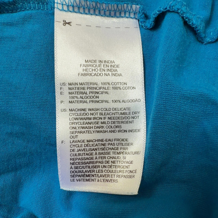 Blue Reebok graphic t-shirt back view showing distressed graphic design, worn with black leggings