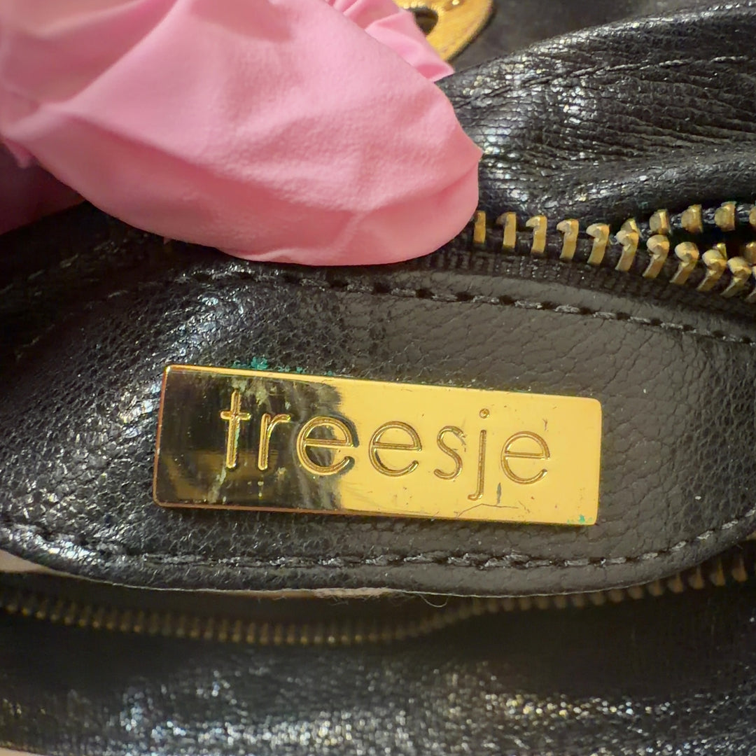 Black quilted leather clutch worn as a waist bag with gold hardware detail