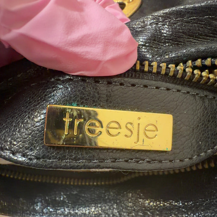 Black quilted leather clutch worn as a waist bag with gold hardware detail