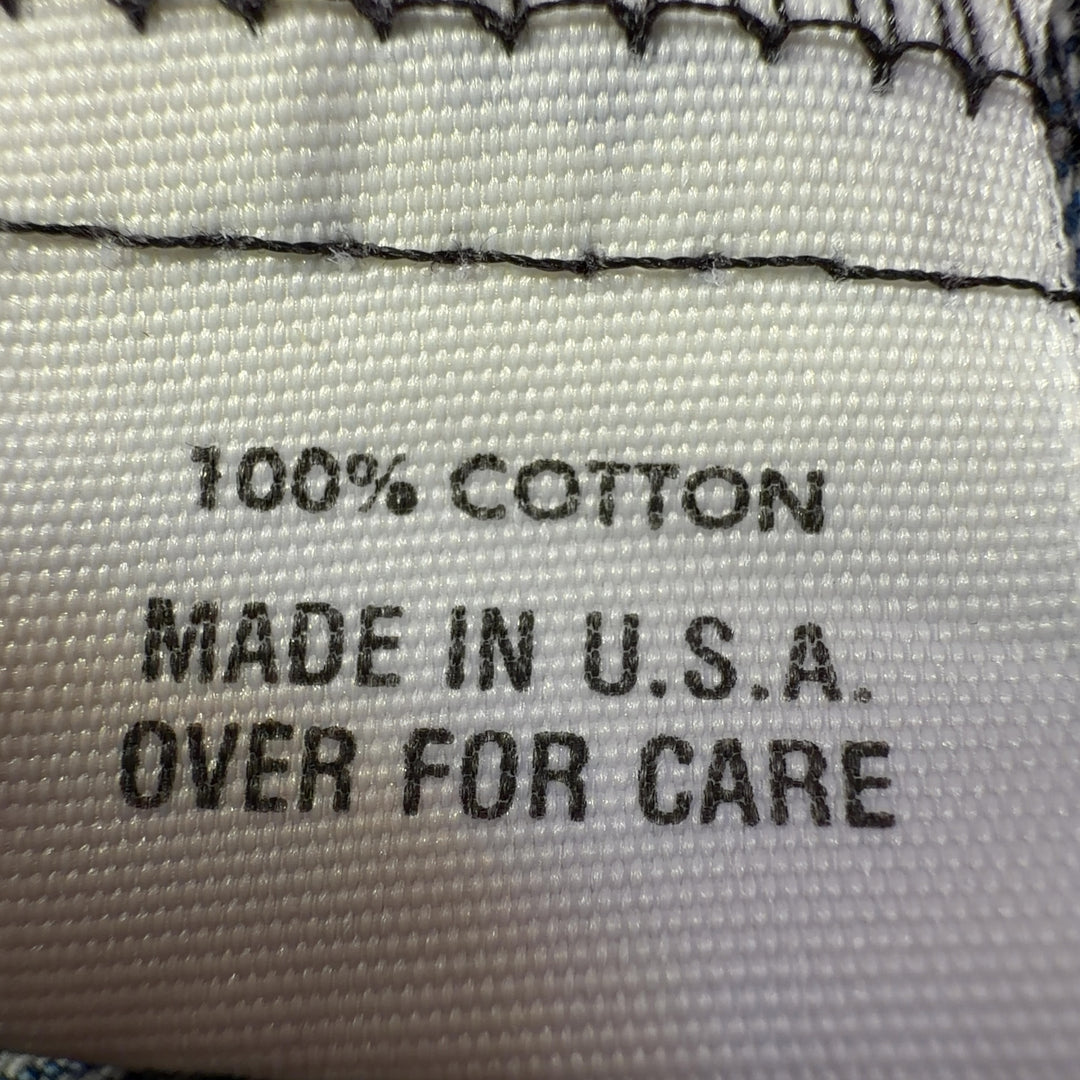 Tag view of cropped blue denim blazer showing tailored fit and length