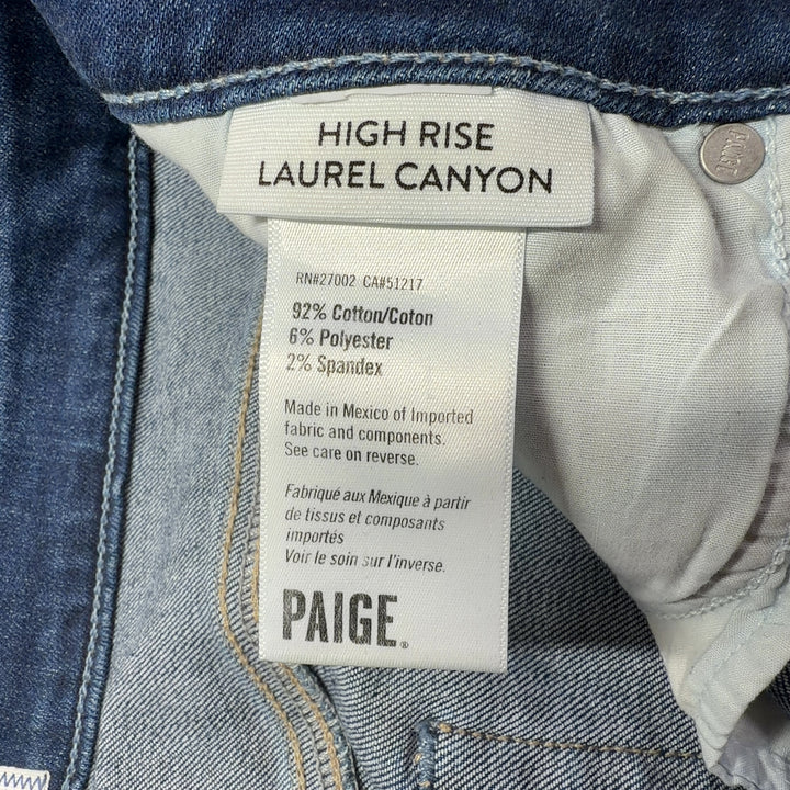 Woman wearing blue high-waisted flare denim jeans by Paige, back view showing flare silhouette