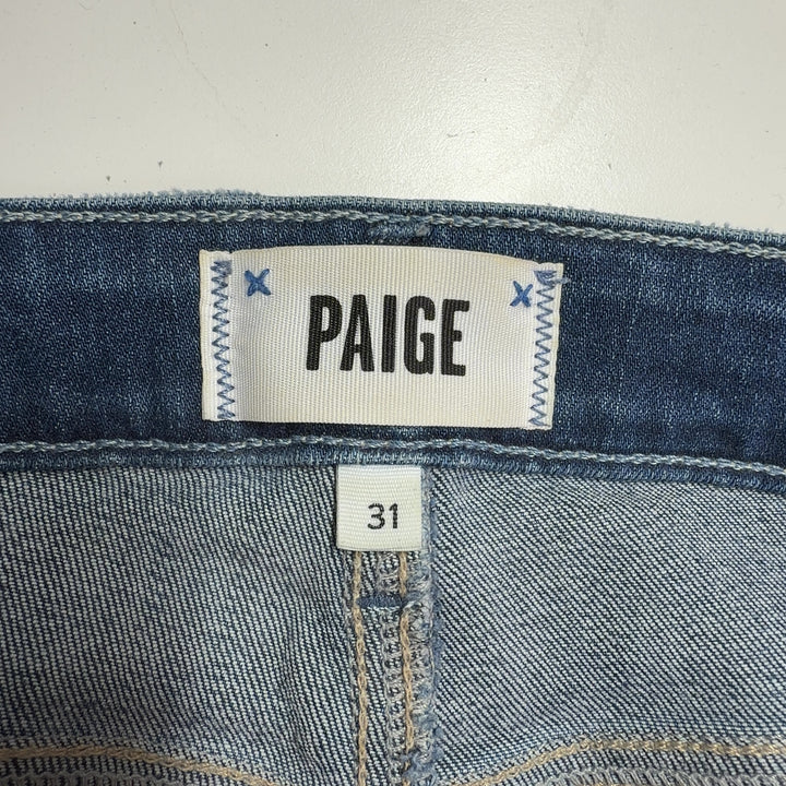 Woman wearing blue high-waisted flare denim jeans by Paige, back view showing flare silhouette