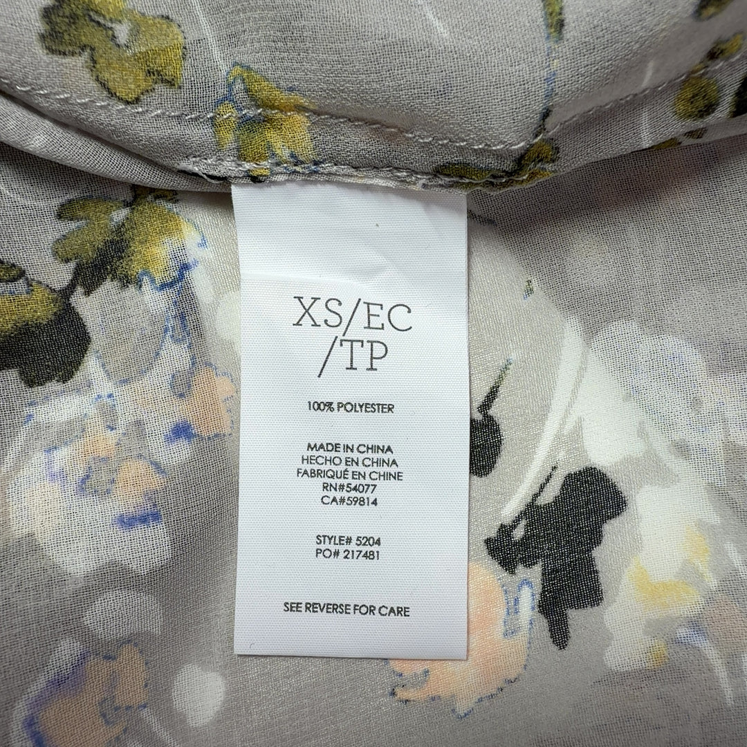 Tag view of cream floral print Cabi button-up shirt showing relaxed fit and full botanical print design
