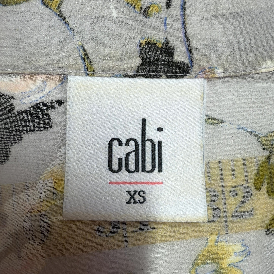 Tag view of cream floral print Cabi button-up shirt showing relaxed fit and full botanical print design