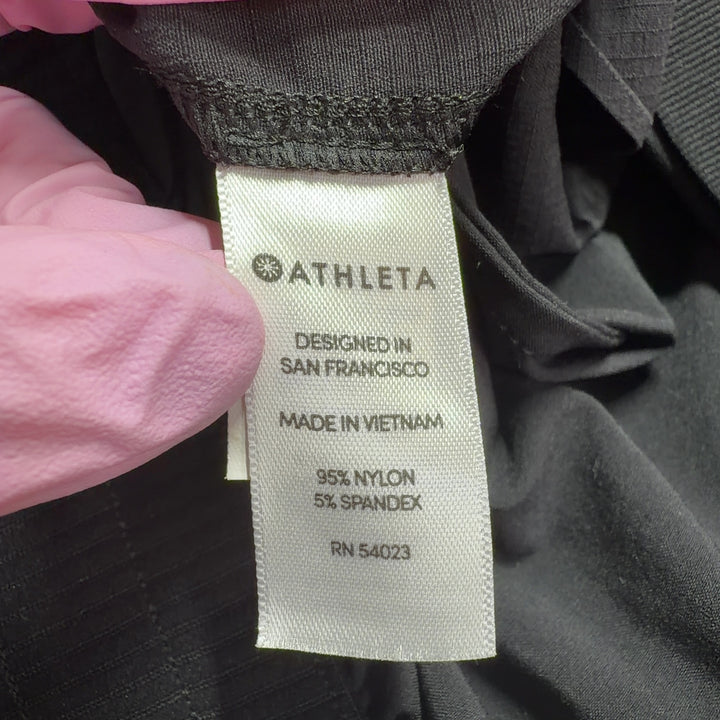 Black Athleta athletic shorts shown from back view, displaying flattering silhouette and side vent details