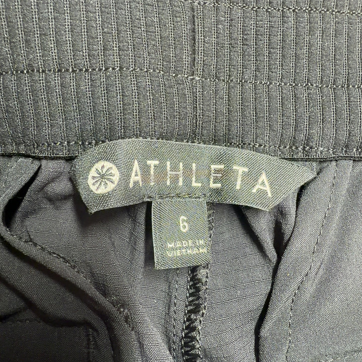 Black Athleta athletic shorts shown from back view, displaying flattering silhouette and side vent details