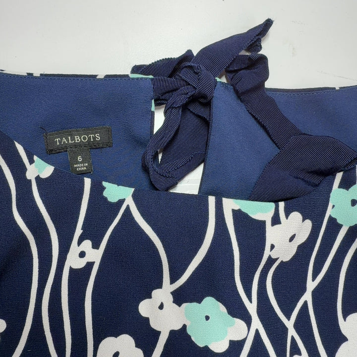 Navy floral canvas dress with bell sleeves, back view on model wearing yellow heels