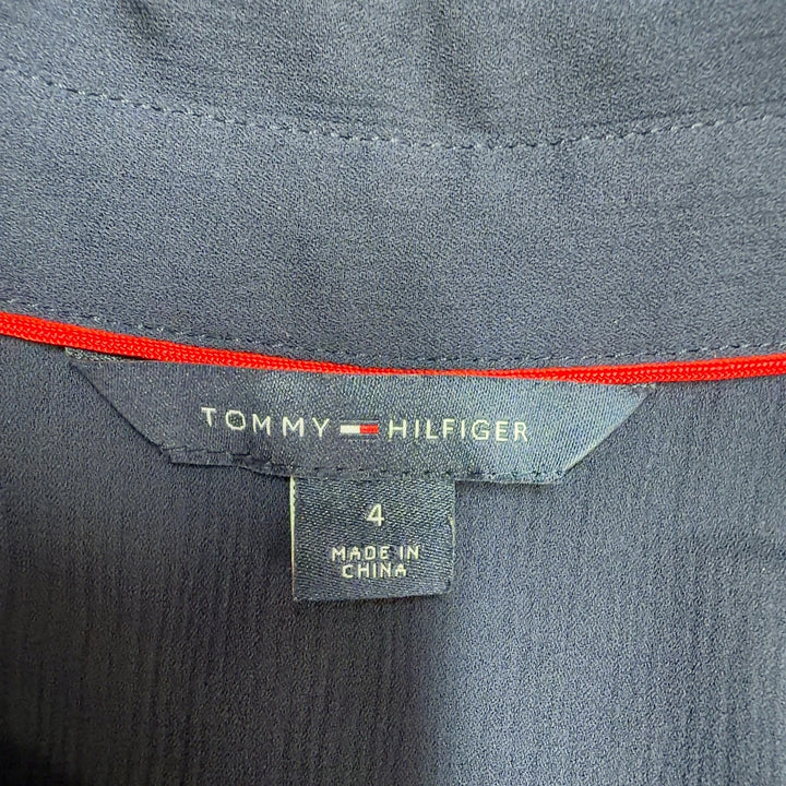 Tag view of navy pleated dress showing red and white striped pleated skirt design