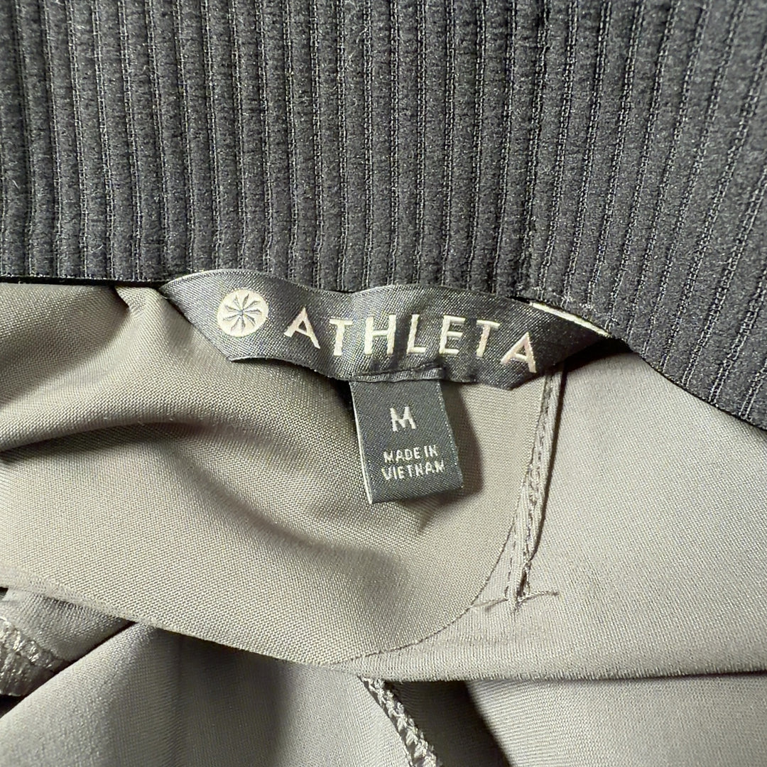 Olive green Athleta activewear pants back view, showing flattering fit and drape