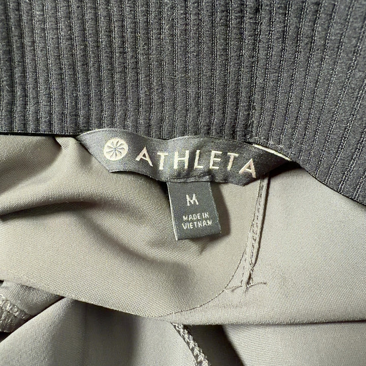 Olive green Athleta activewear pants back view, showing flattering fit and drape
