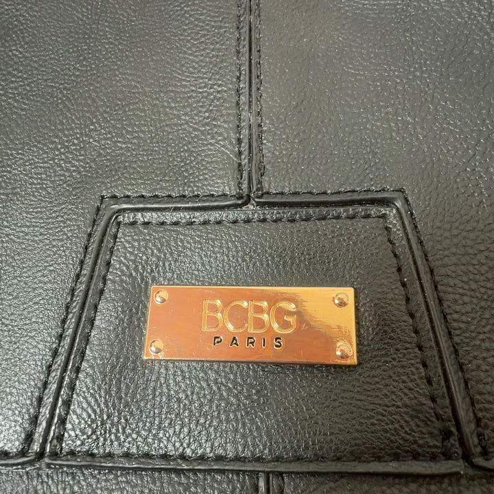 Black leather fold-over clutch styled with black outfit, showing back view and compact design