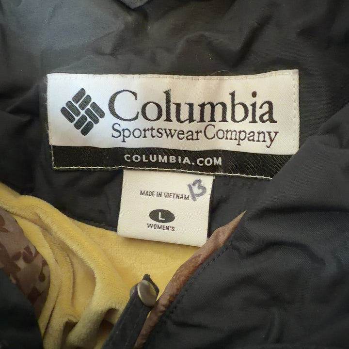 Black Columbia windbreaker jacket with white stripe details, back view showing hooded design and relaxed fit