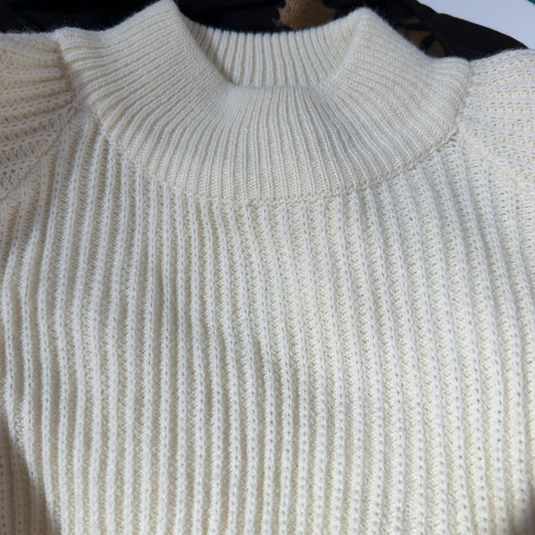 Tag view of cream ribbed knit sweater dress showing oversized fit and knee-length hem