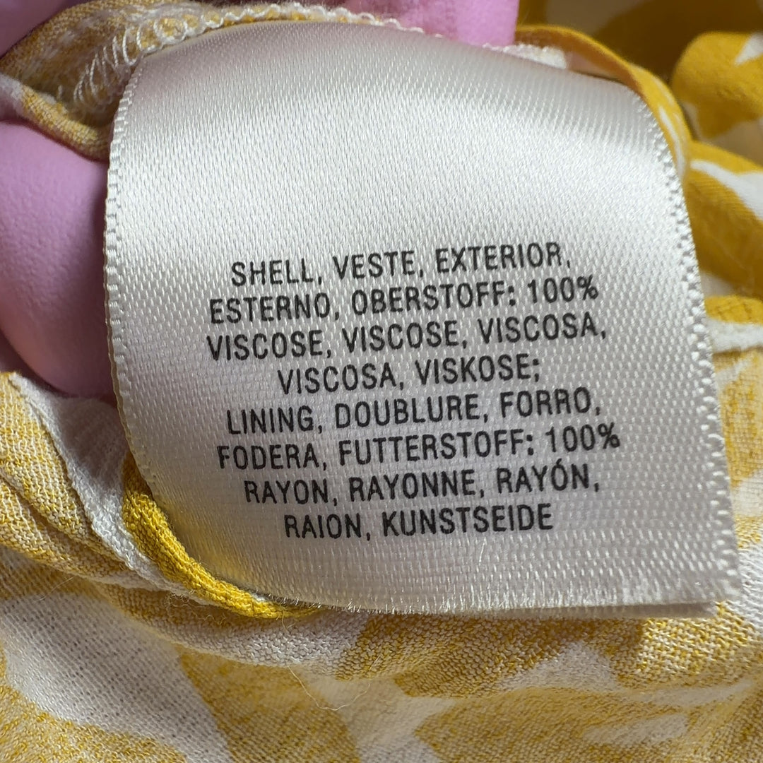 Tag view of yellow abstract print Maeve all-in-one jumpsuit showing flowing wide-leg design