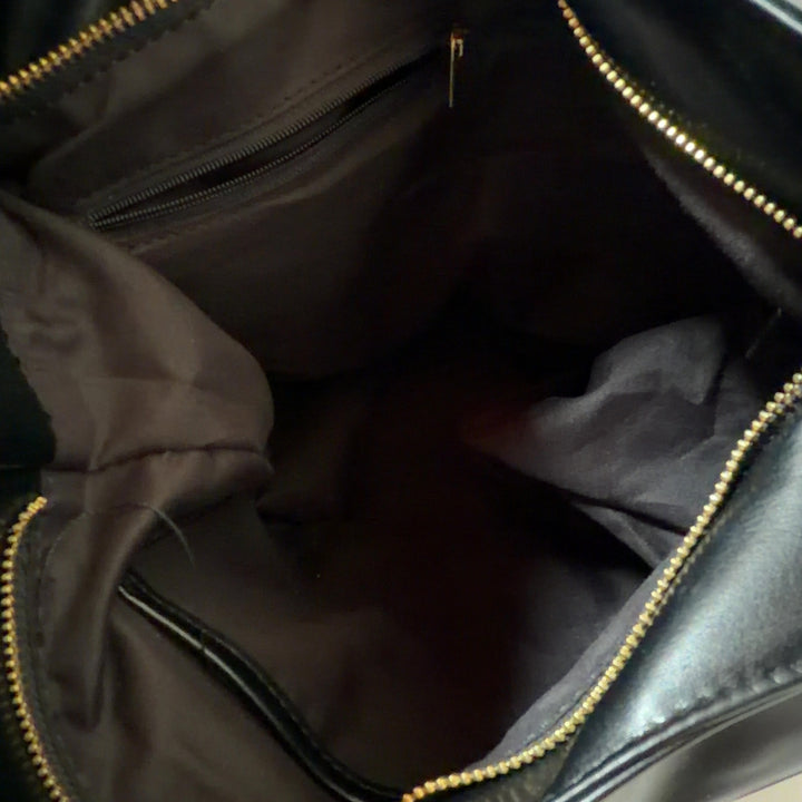 Black leather hobo shoulder bag worn on shoulder, back view showing slouchy silhouette