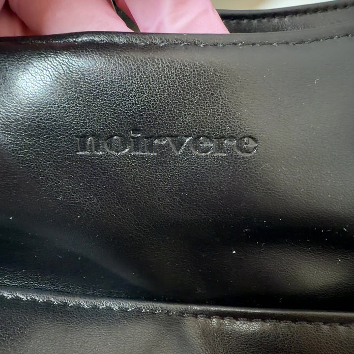 Black leather hobo shoulder bag worn on shoulder, back view showing slouchy silhouette