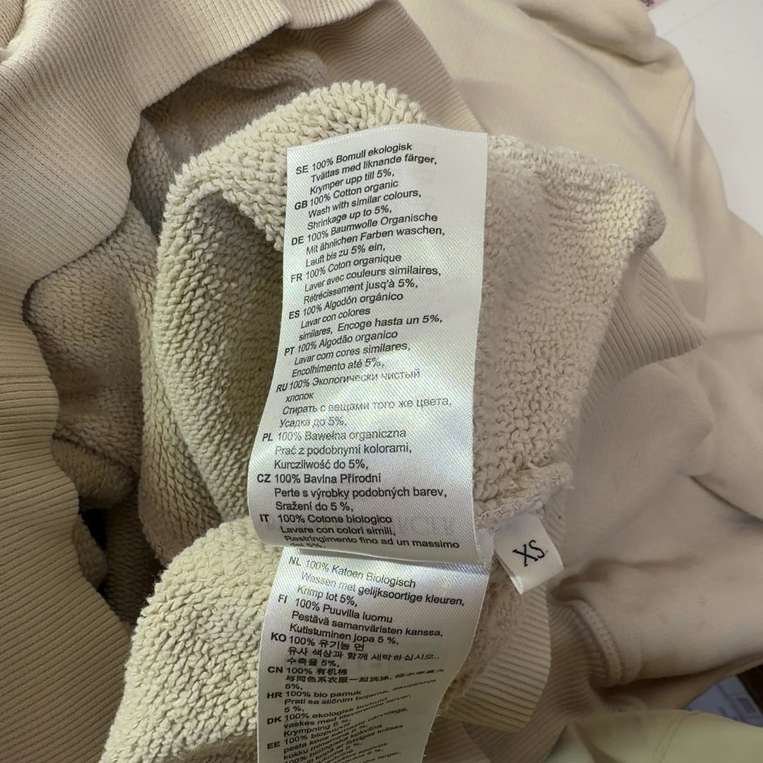 Tag view of cream organic cotton hoodie sweatshirt showing hood and relaxed silhouette