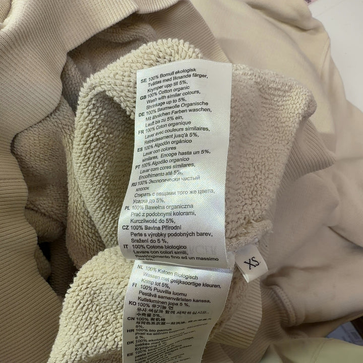 Tag view of cream organic cotton hoodie sweatshirt showing hood and relaxed silhouette