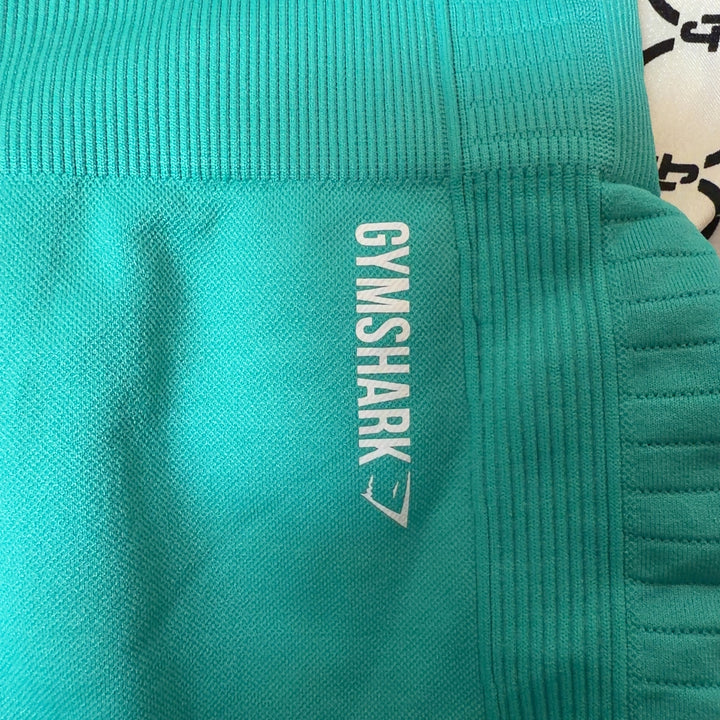 Side view of turquoise seamless cropped leggings showing textured mesh detailing and fitted silhouette