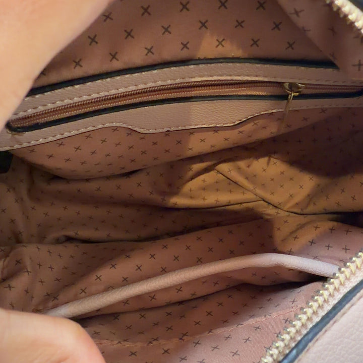 Tag view of cream SilkRoll clutch bag worn as crossbody style with gold hardware details