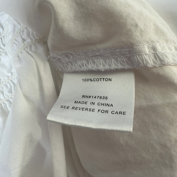 Tag view of white cotton ruched button-up shirt showing tailored fit and button closure