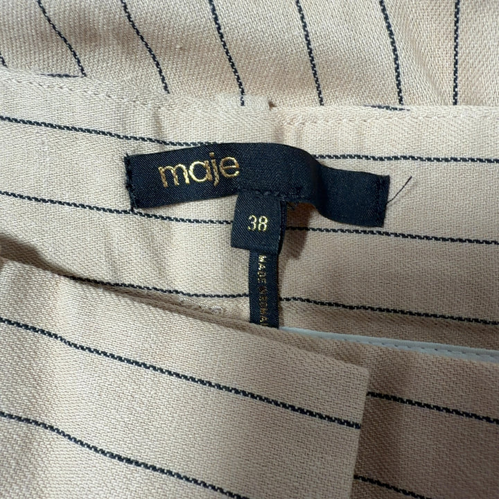 Tag view of cream pinstriped Maje trousers showing pleated detailing and tailored silhouette