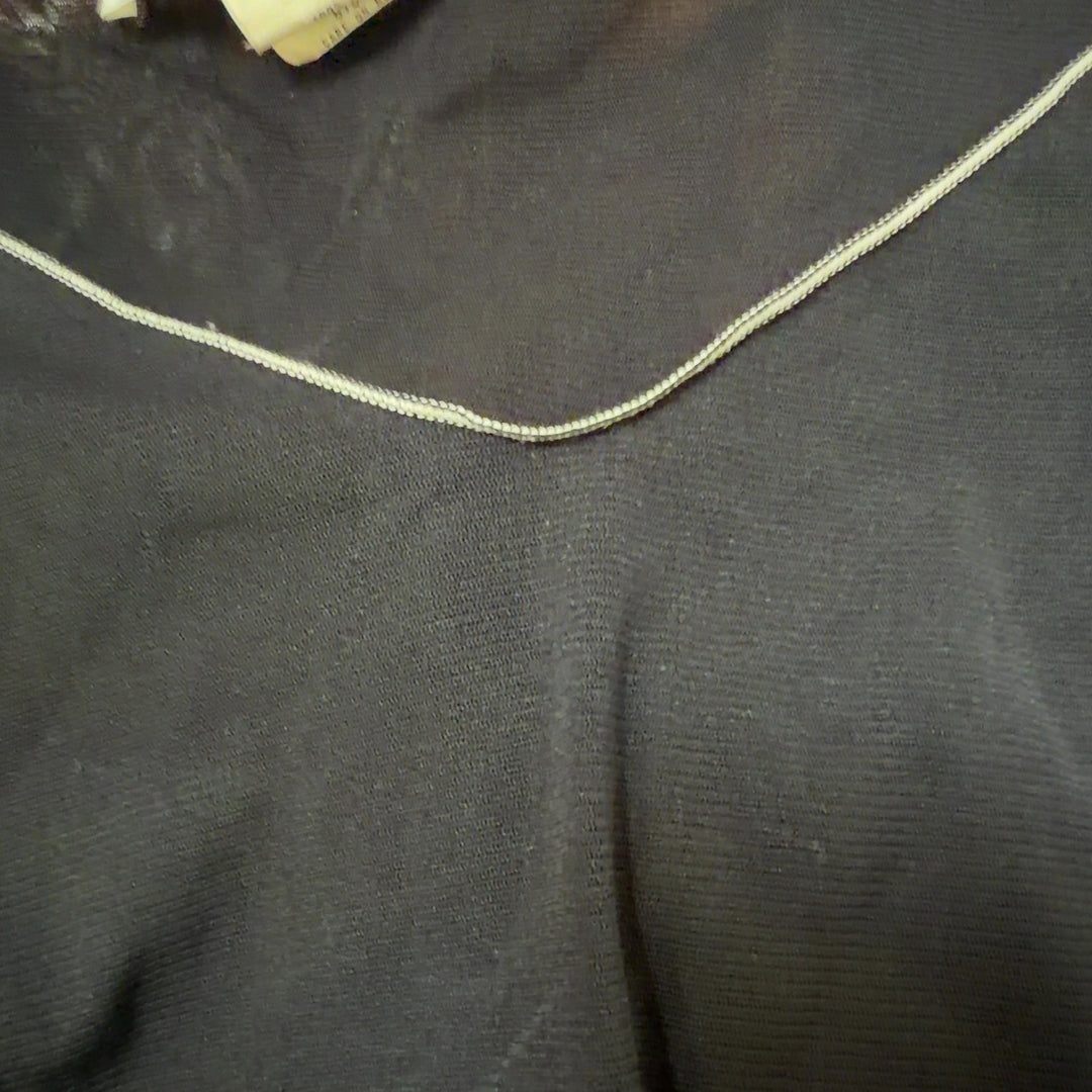 Tag view of black flutter sleeve v-neck top showing relaxed fit and contrast stitching