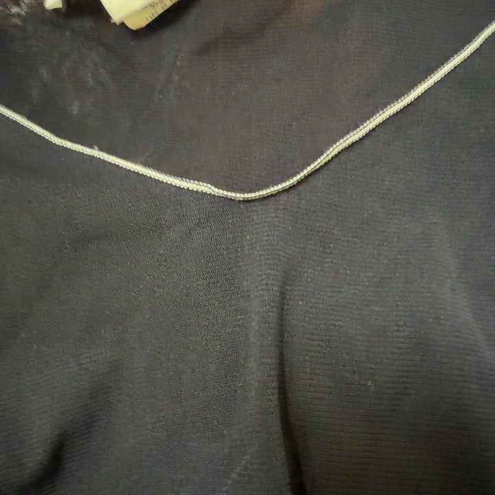 Tag view of black flutter sleeve v-neck top showing relaxed fit and contrast stitching