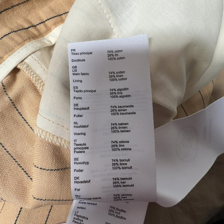 Tag view of cream pinstriped Maje trousers showing pleated detailing and tailored silhouette
