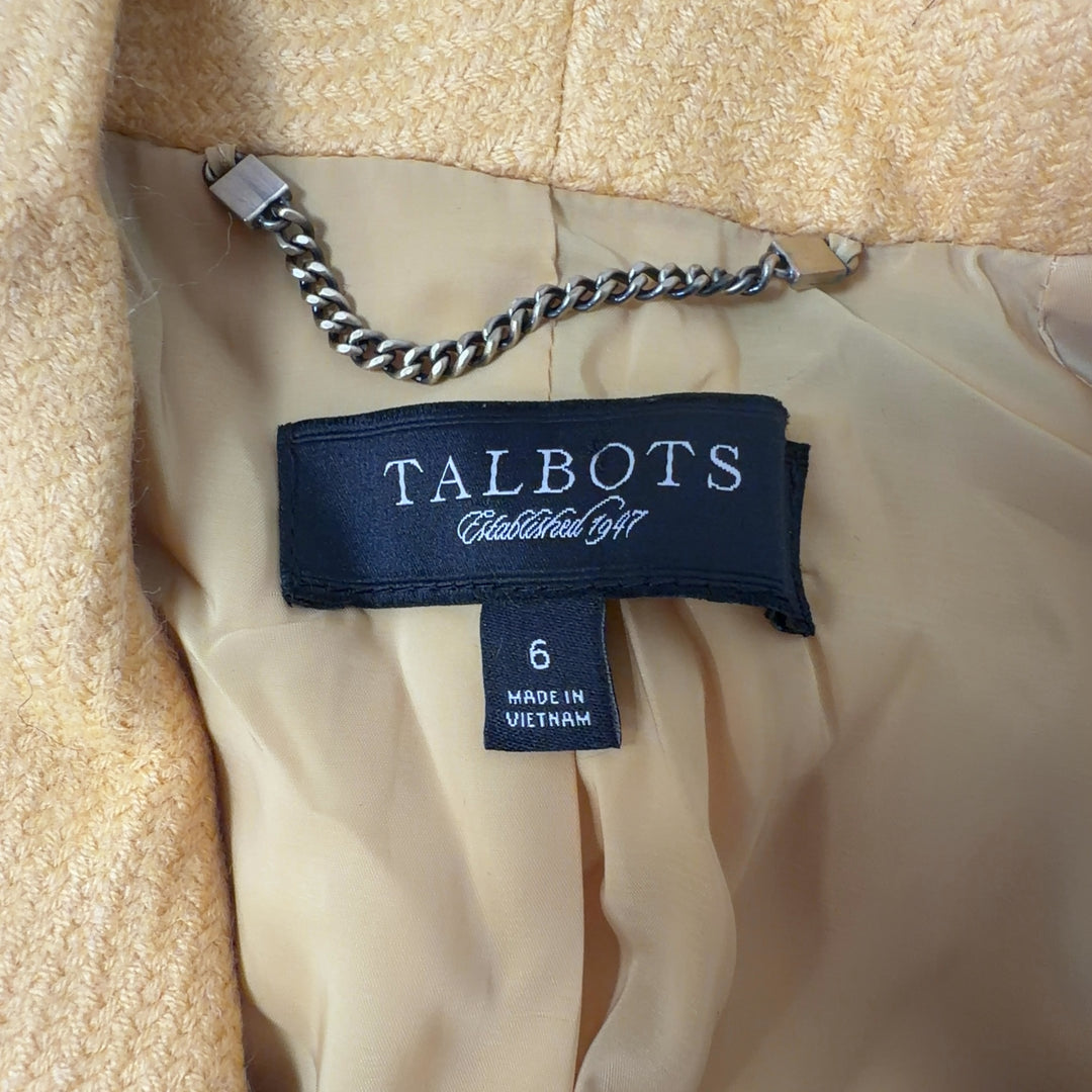 Tag view of yellow tailored blazer showing cropped length and structured silhouette