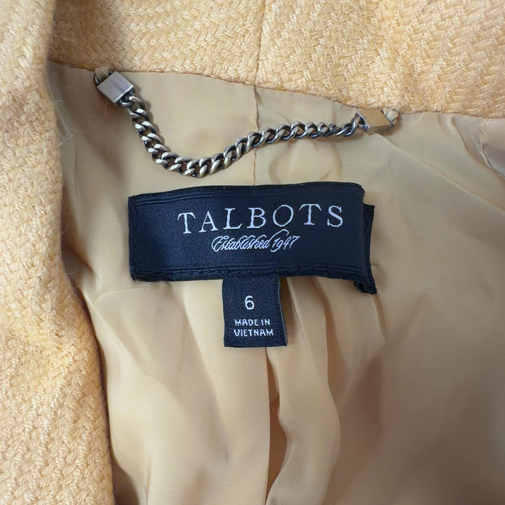Tag view of yellow tailored blazer showing cropped length and structured silhouette