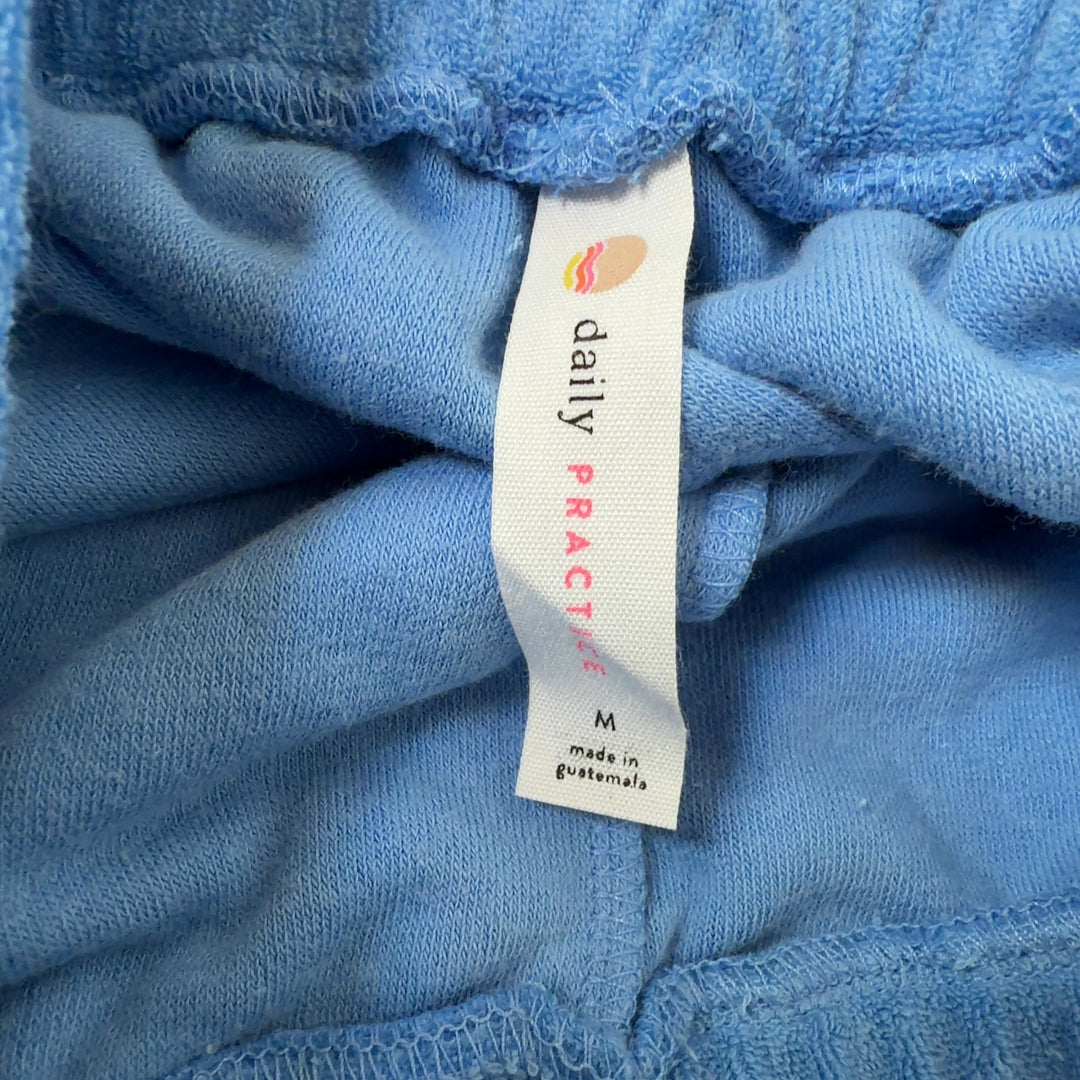Light blue denim athletic shorts with drawstring waist and white contrast trim, back view