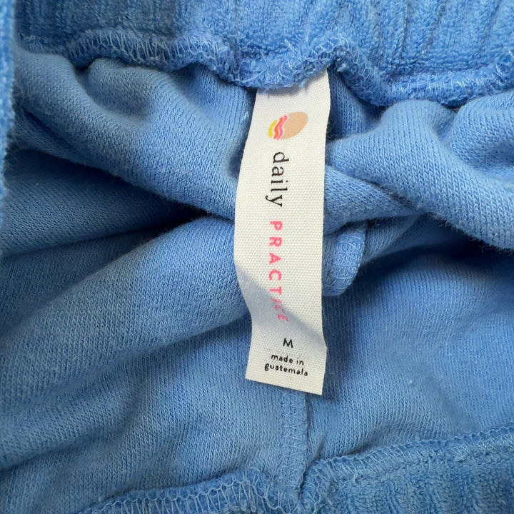Light blue denim athletic shorts with drawstring waist and white contrast trim, back view