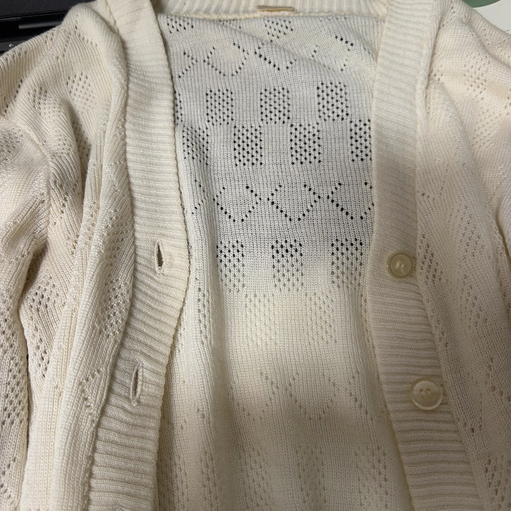 Tag view of cream cable knit cardigan showing textured pattern and cropped length