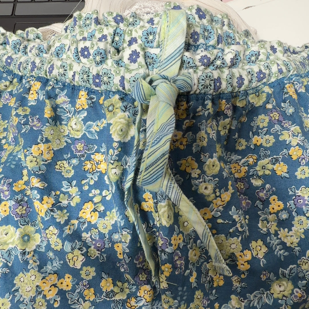 Tag view of blue floral shorts showing lace trim detail and comfortable relaxed silhouette