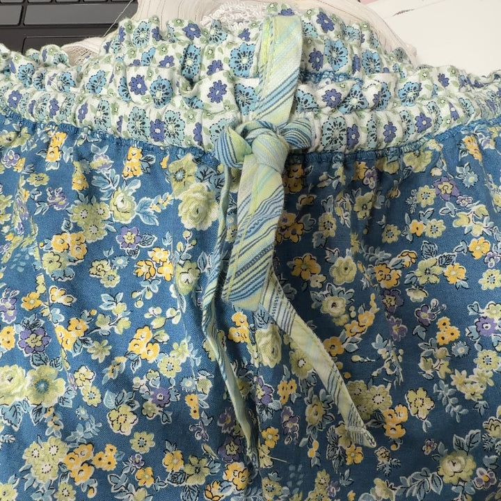 Tag view of blue floral shorts showing lace trim detail and comfortable relaxed silhouette