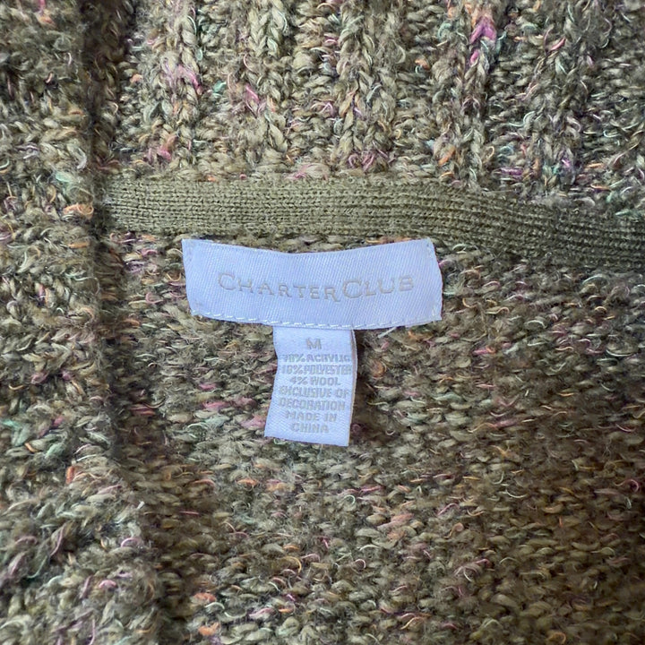 Tag view of olive green knit cardigan showing relaxed fit and ribbed hem detail
