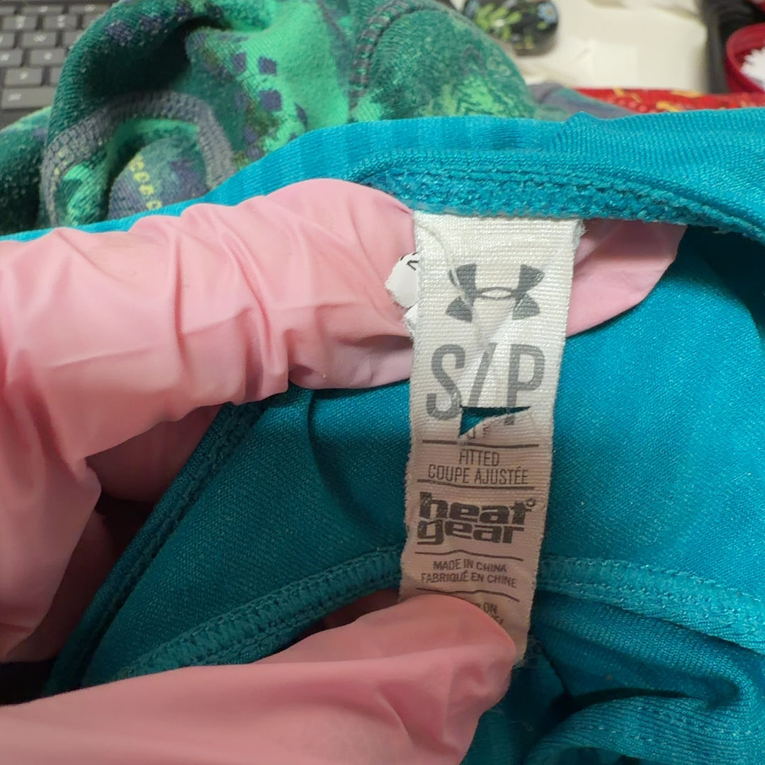 Woman wearing turquoise striped Under Armour racerback athletic tank, back view showing fitted silhouette