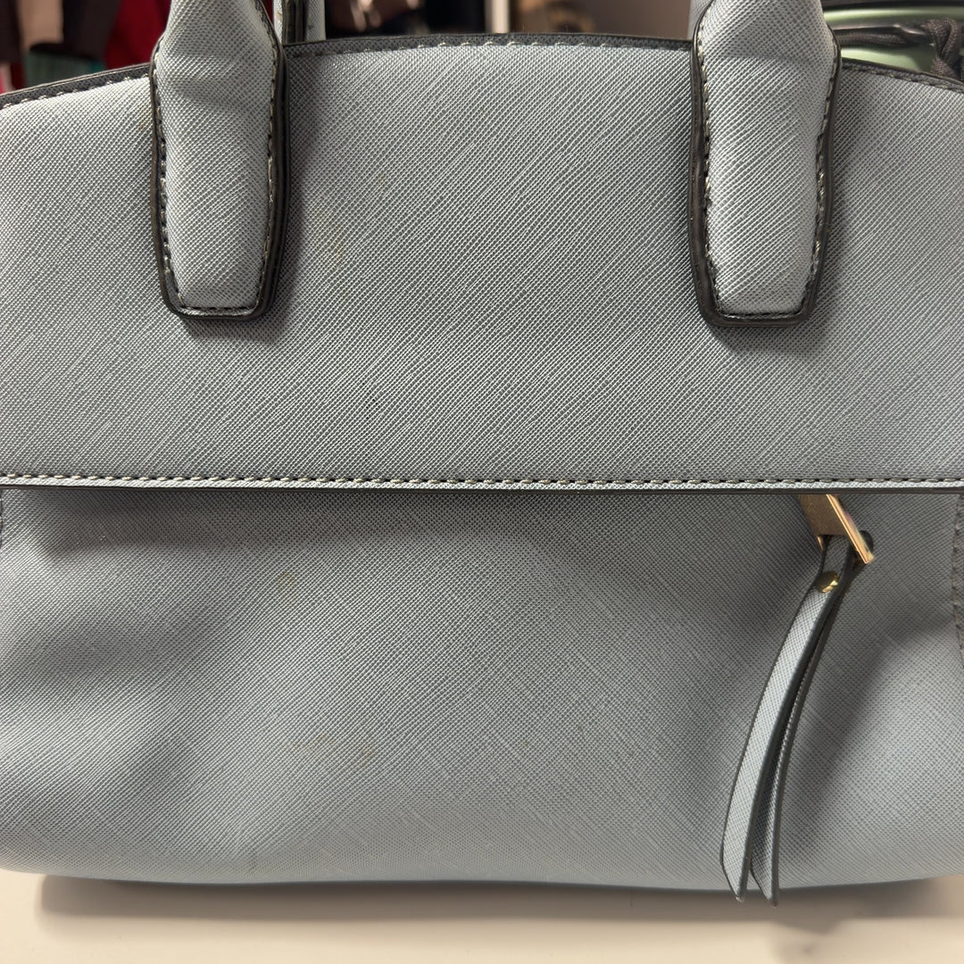 Tag view of light blue SilkRoll shoulder bag worn as crossbody style, showing structured silhouette and adjustable strap design