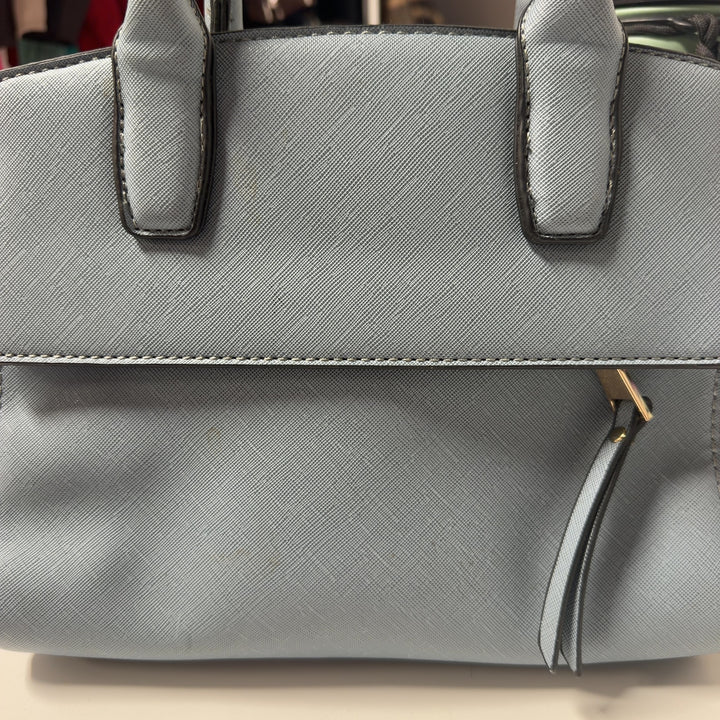 Tag view of light blue SilkRoll shoulder bag worn as crossbody style, showing structured silhouette and adjustable strap design