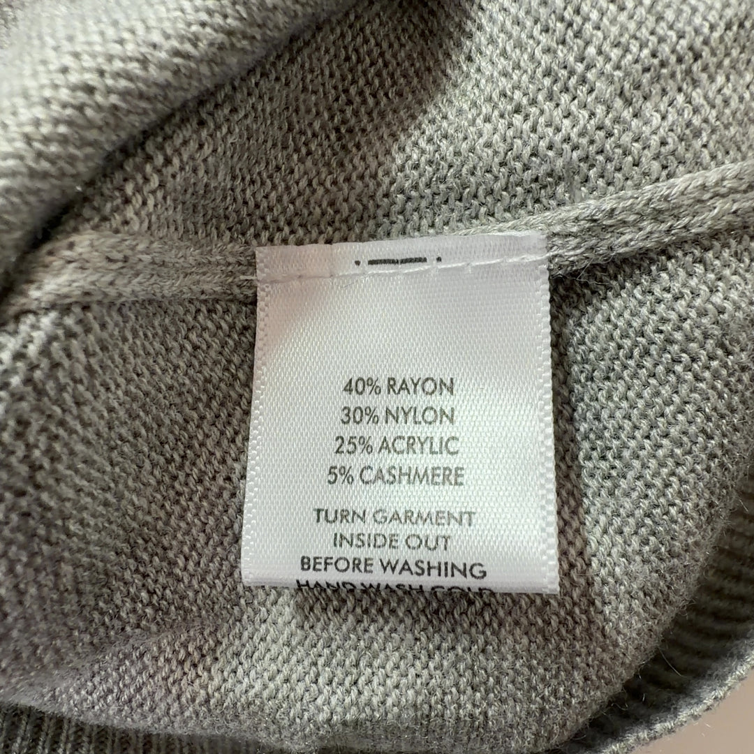 Tag view of beige knit pullover sweater showing clean silhouette and relaxed fit